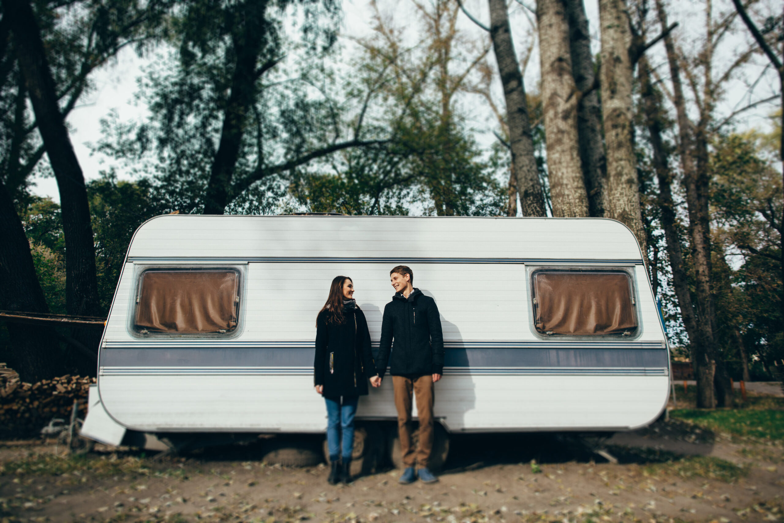Couple. Couple in love holding hands and looking at each other and smiling. Couple in love walking near camper